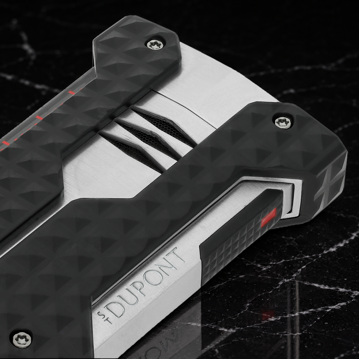 Close-up of the S.T. Dupont Windproof lighter in brushed chrome, showing the recessed burner vents and corner bumpers