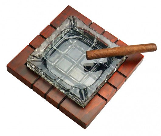 Wood and crystal cross-hatched cigar ashtray with a cigar resting, angled view