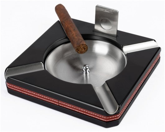 Leather-trim cigar ashtray with cutter, black with red stitching, a cigar on one of the four rests