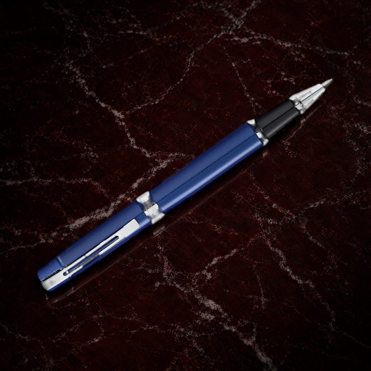 Sheaffer 300 Pen — Glossy Blue with Chrome Trim: the rollerball in glossy blue lacquer with polished chrome trim, on garnet marble