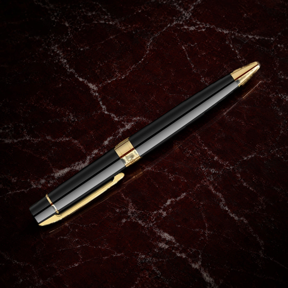 Sheaffer 300 Pen — Glossy Black with Gold Trim: the ballpoint in glossy black lacquer with gold-tone trim, on garnet marble