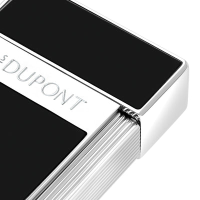 Close-up of the S.T. Dupont Biggy lighter in black lacquer, showing the engraved S.T. Dupont band and fluted chrome roller