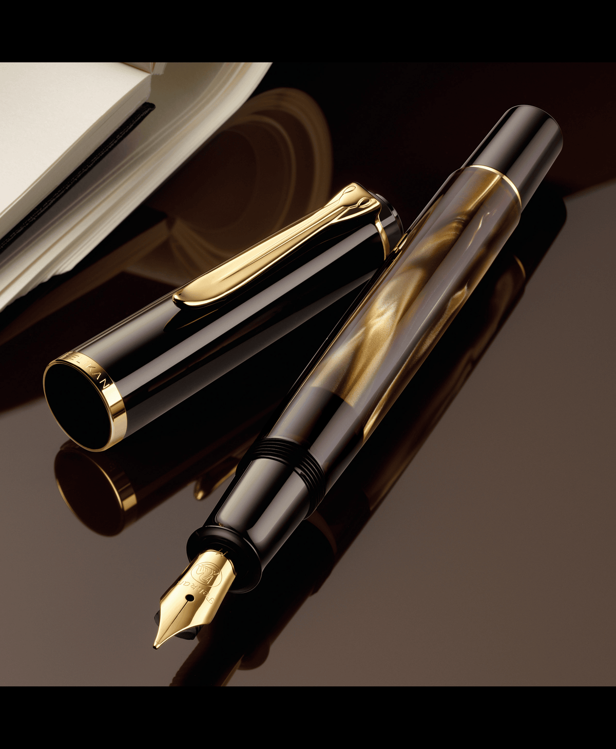Pelikan M200 fountain pen in brown marbled resin, uncapped beside its cap on a dark reflective surface