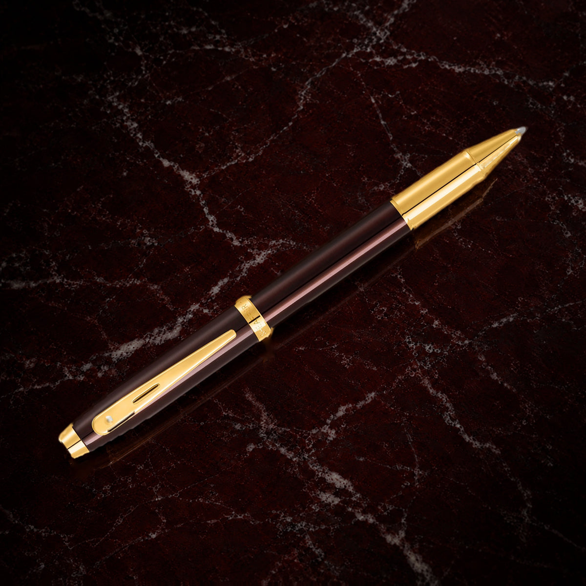 Sheaffer 100 Pen — Coffee Brown with Gold Trim: the rollerball in coffee brown lacquer with PVD gold trim, on garnet marble