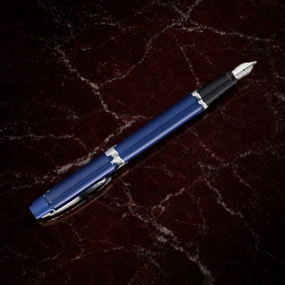 Sheaffer 300 Pen — Glossy Blue with Chrome Trim: the fountain pen in glossy blue lacquer with polished chrome trim, on garnet marble