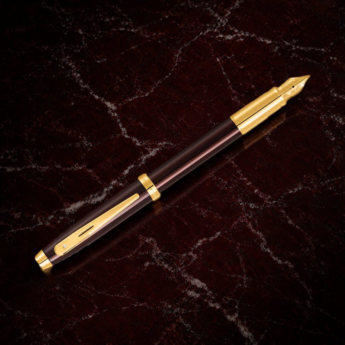 Sheaffer 100 Pen — Coffee Brown with Gold Trim: the fountain pen in coffee brown lacquer with PVD gold trim, on garnet marble