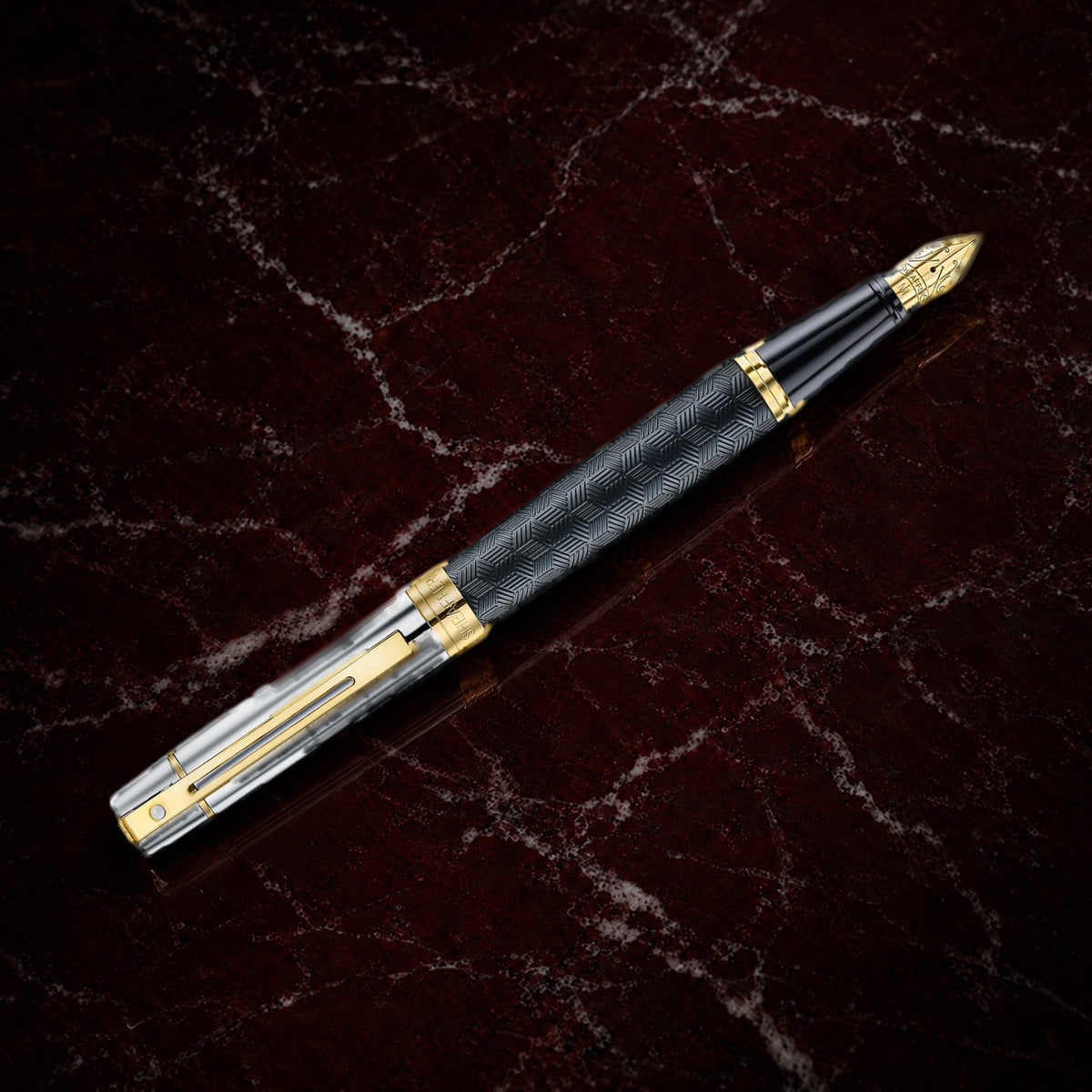 Sheaffer 300 Pen — Engraved Matte Black with Chrome Cap: the fountain pen with an engraved matte black barrel, chrome cap and PVD gold trim, on garnet marble