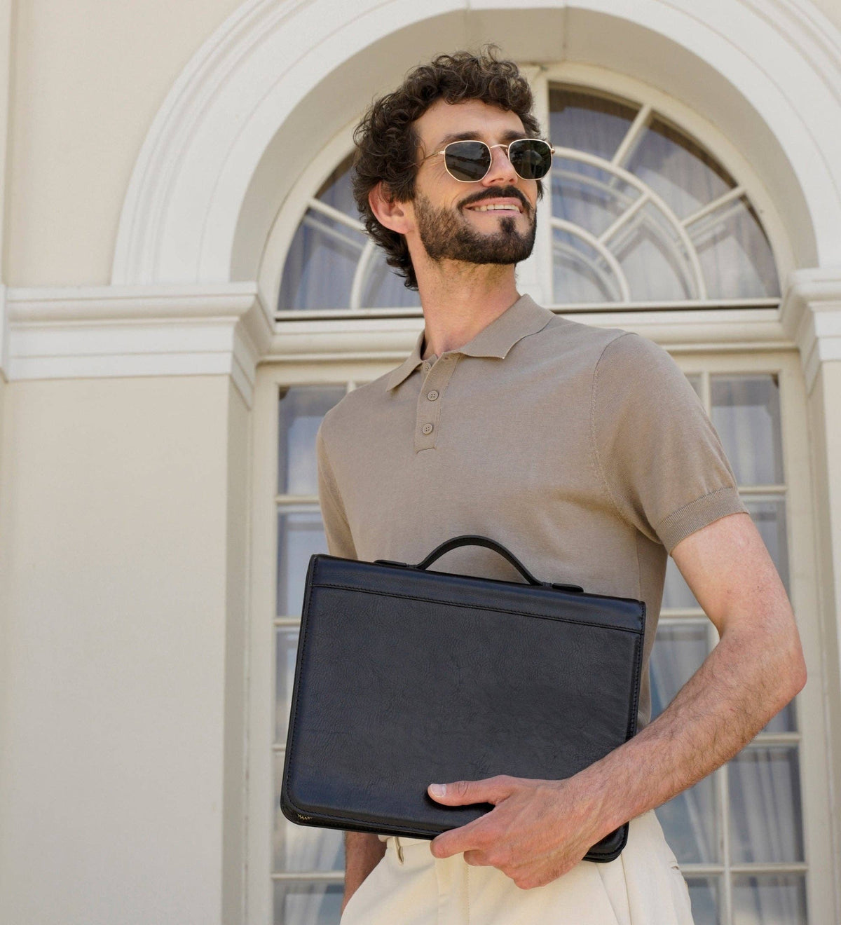 Joy in the Morning leather binder portfolio held by a model in a doorway