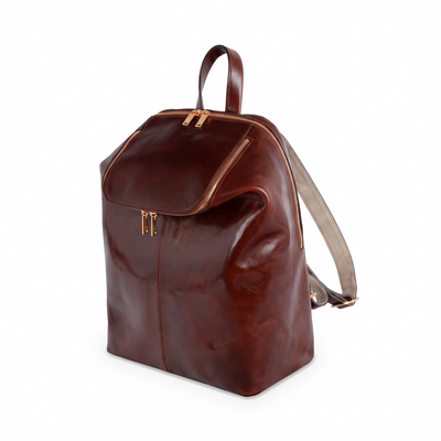A Bend in the River — Women's Leather Backpack in brown Italian Vachetta, three-quarter view with dome top and shoulder strap, on a white background