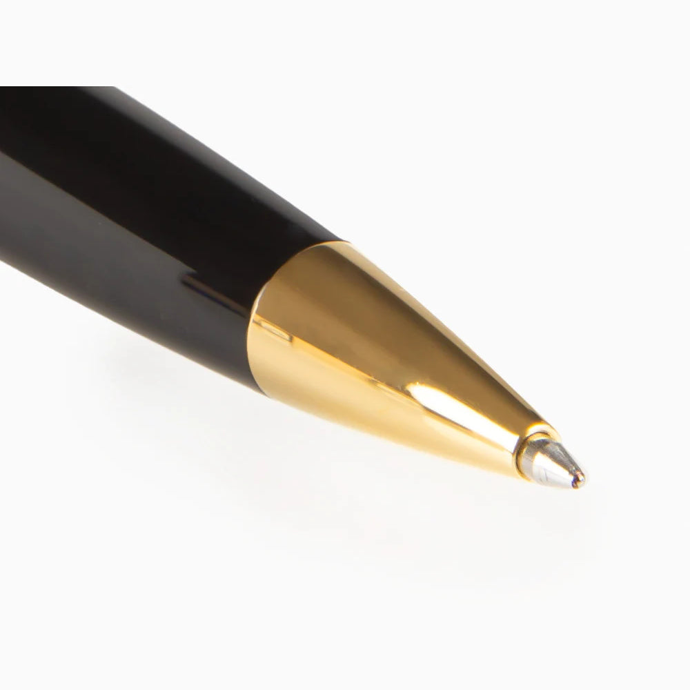 Close-up of the Esterbrook Estie Ballpoint's writing end — the polished gold-tone cone tapering to the ballpoint tip, against the gloss black Ebony barrel