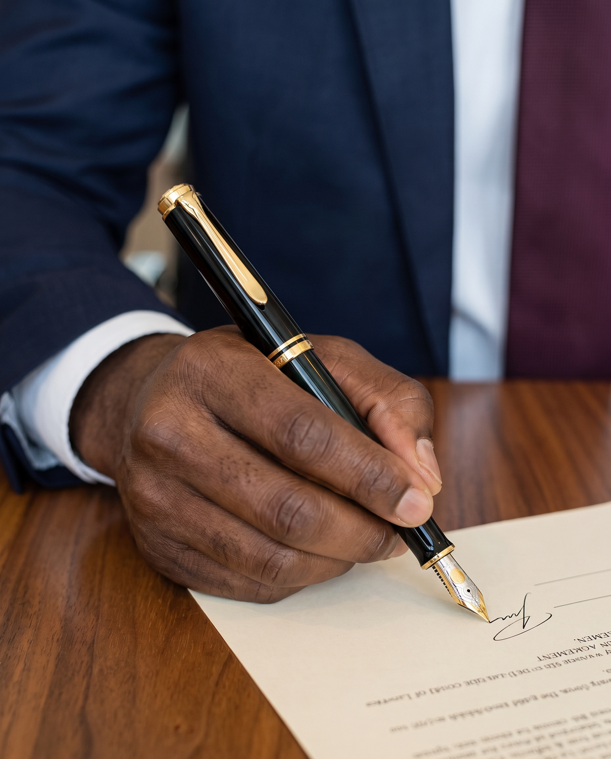 Pelikan Souverän M800 Fountain Pen — close view of the black M800 with gold trim and two-tone gold nib signing a settlement agreement