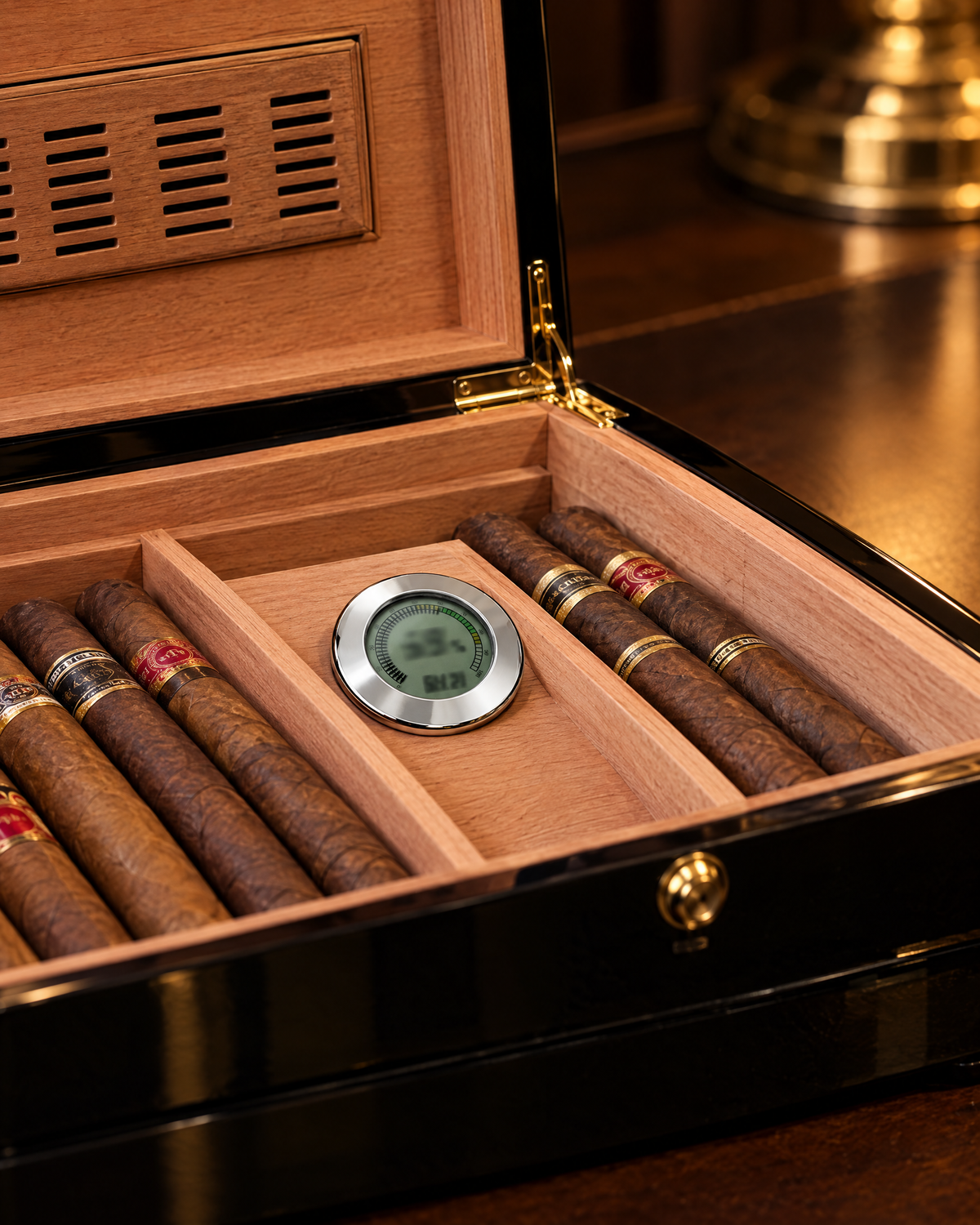 Digital Hygrometer with Calibration in polished silver resting on the cedar divider inside an open humidor