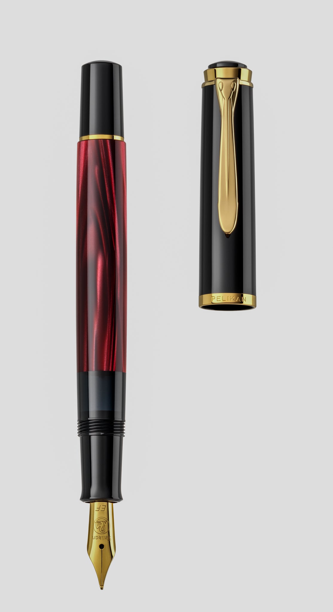 Pelikan M200 fountain pen in red marbled resin, shown with the cap removed and standing alongside the barrel and gold nib