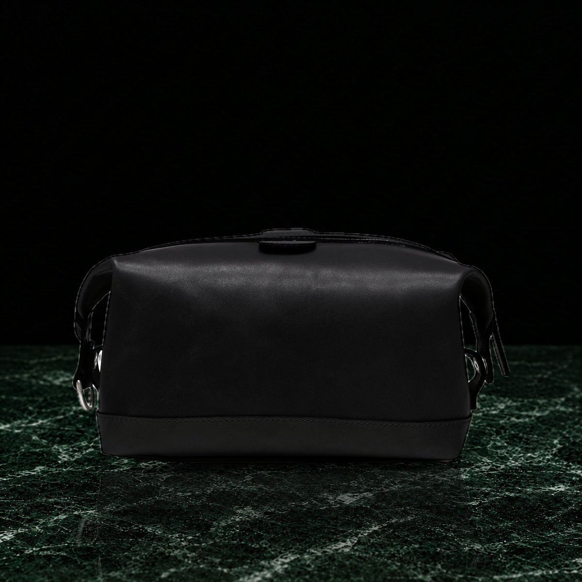 Ryder full-grain leather dopp kit in black, back view on dark green marble