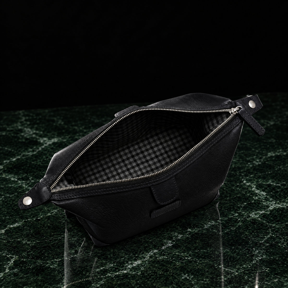 Ryder full-grain leather dopp kit in black, open to show the check cotton twill lining