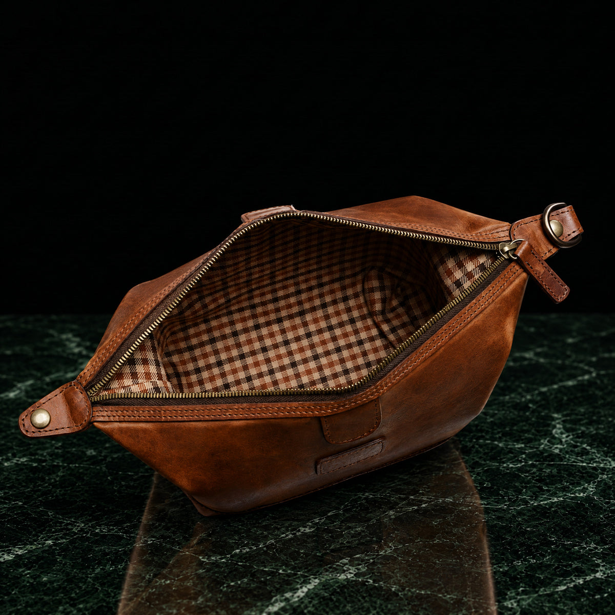 Ryder full-grain leather dopp kit in brown, open to show the check cotton twill lining