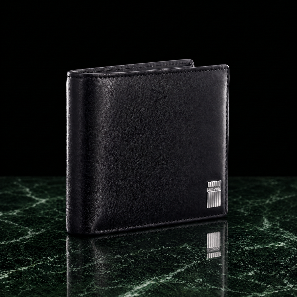 S.T. Dupont Iconic billfold wallet in black leather, closed and standing at an angle on dark green marble, side light showing the leather grain and stitching, the silver-tone plaque at the lower right