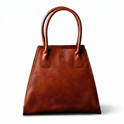 The Woman in White — Women's Leather Tote in cognac brown matte leather, front view with the sides folded in, on a white background