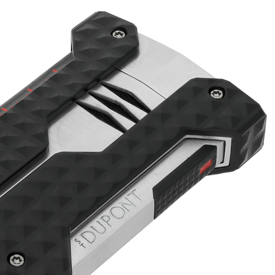 Close-up of the S.T. Dupont Windproof lighter in brushed chrome, showing the recessed burner vents and corner bumpers