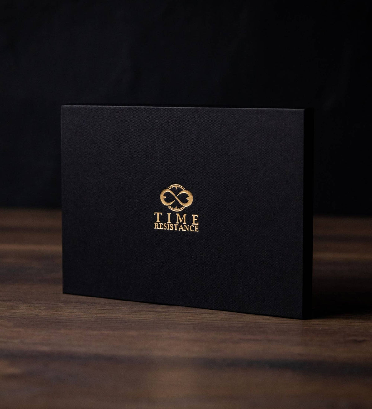 The Time Resistance presentation box the tote ships in: matte black card with the gold Time Resistance monogram and wordmark