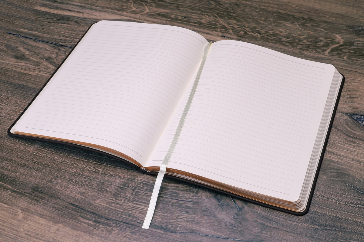 Large Leather Journal opened to ruled pages, sewn binding lying flat