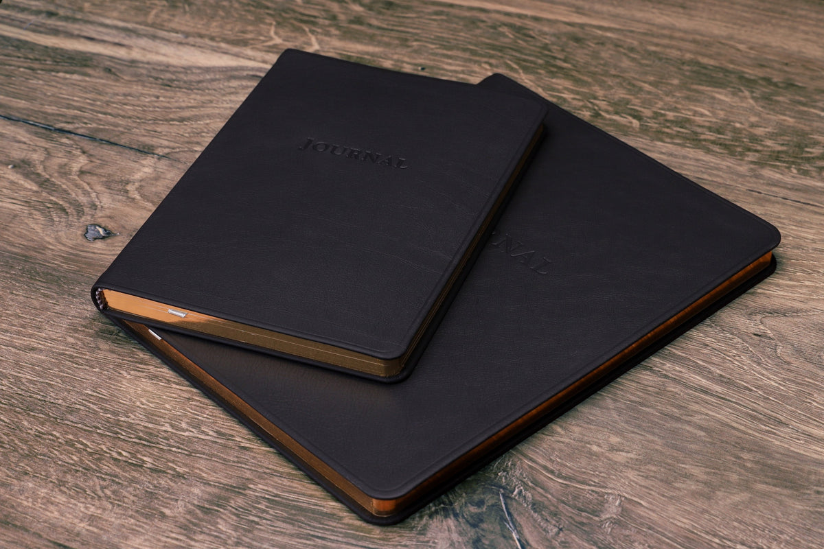 Large Leather Journal beside the Desk Leather Journal, both closed, for scale