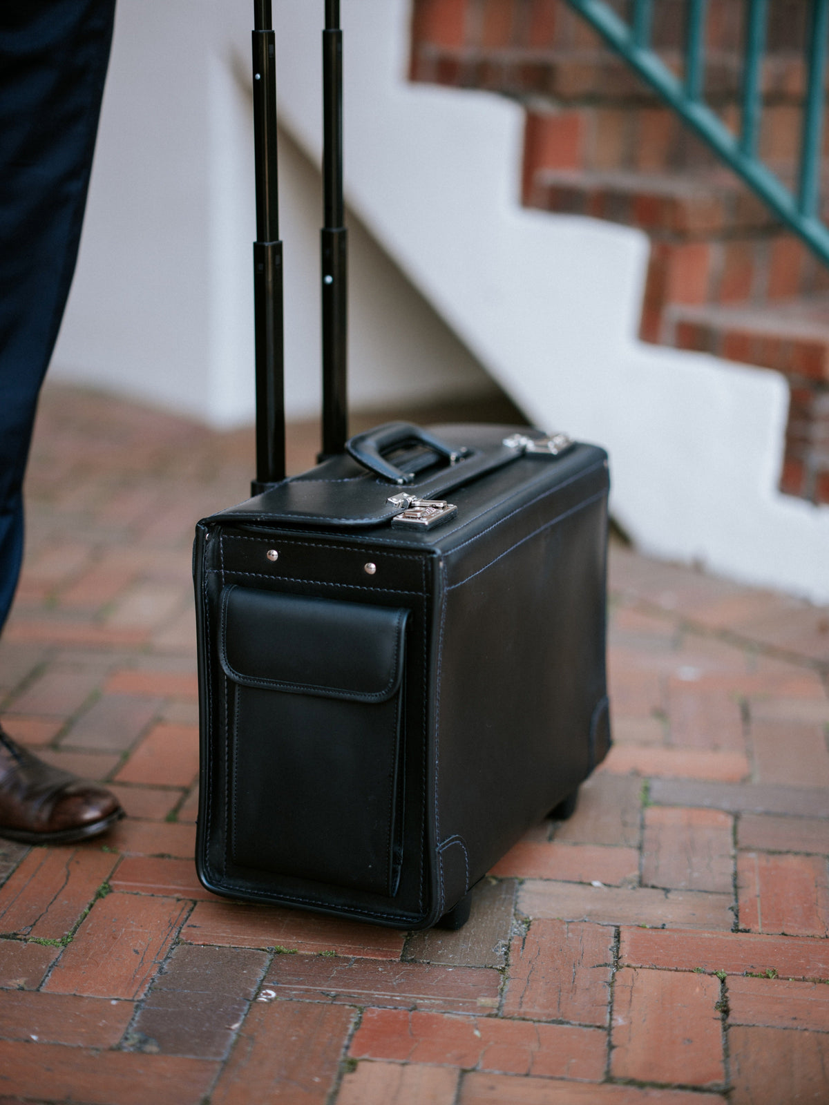 Litigator wheeled catalog case in black rolled through a brick courtyard